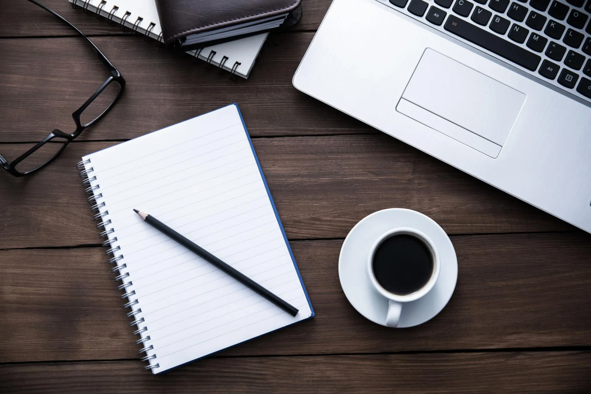 Notebook, laptop, coffee, and desk setup for money transfer guides